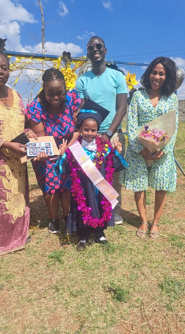 A learner celebrating graduation with a group of adults